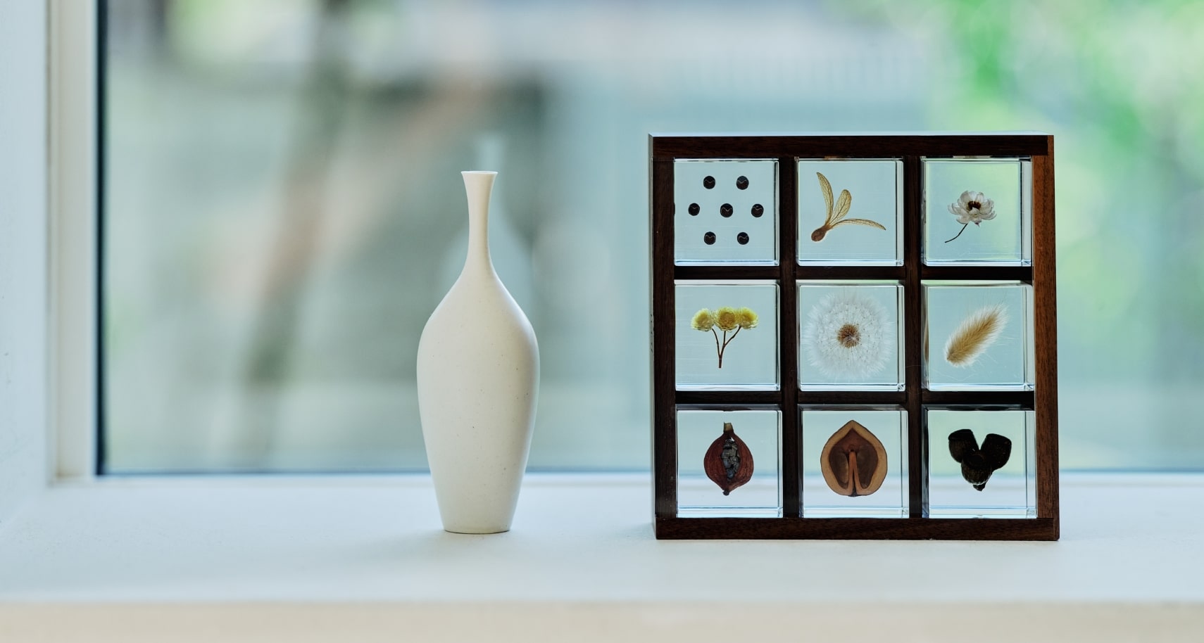 Nine Sola cubes in a storage box placed on a window sill